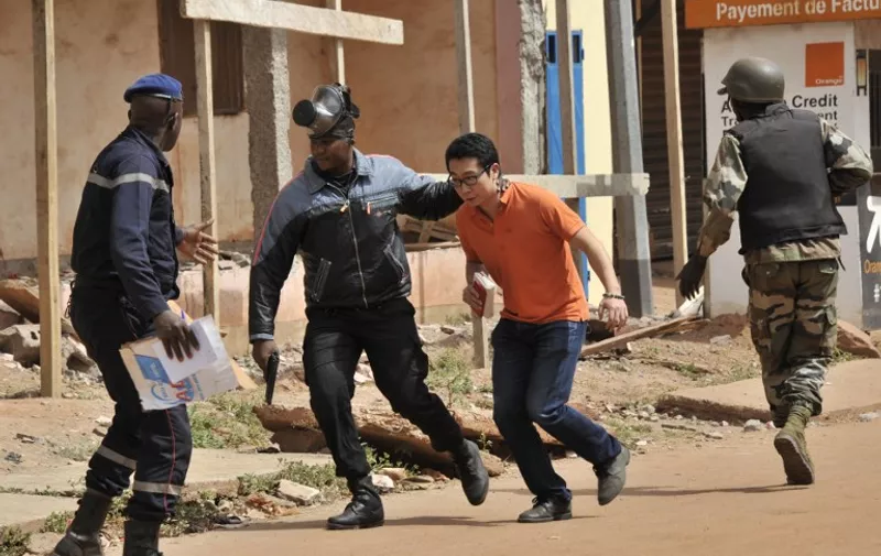 Malian security forces evacuate a man from an area surrounding the Radisson Blu hotel in Bamako on November 20, 2015. Gunmen went on a shooting rampage at the luxury hotel in Mali's capital Bamako, seizing 170 guests and staff in an ongoing hostage-taking that has left at least three people dead. AFP PHOTO / HABIBOU KOUYATE / AFP / HABIBOU KOUYATE