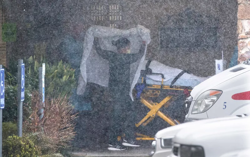KIRKLAND, WA - MARCH 07: A patient is wheeled out of the Life Care Center of Kirkland to an awaiting ambulance on March 7, 2020 in Kirkland, Washington. Several residents have died from COVID-19 and others have tested positive for the novel coronavirus. (Photo by Karen Ducey/Getty Images)