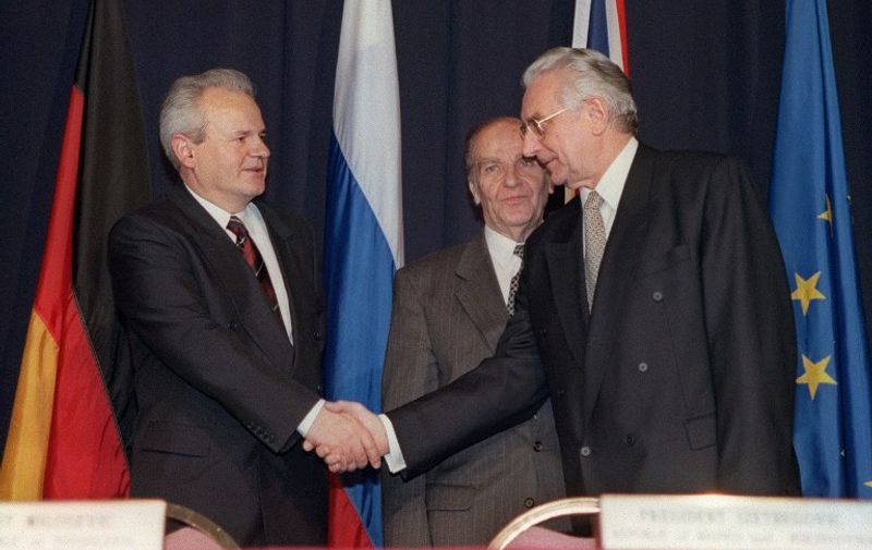 Alija Izetbegovic, President of the Republic of Bosnia-Herzegovina (C) looks on as Franjo Tudjman R), President of the Republic of Croatia, and Slobodan Milosevic (L), President of the Federal Yugoslavia (Serbia and Montenegro) shake hands after initializing a peace accord 21 November 1995 between their countries. Negotiations hosted by the US known as the Proximity Peace Talks at Wright-Patterson Air Force base, near Dayton, Ohion, began 01 November 1995.