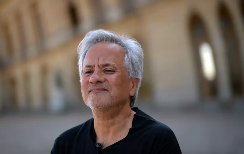 British contemporary artist of Indian origin Anish Kapoor poses outside the Chateau de Versailles, in Versailles on June 5, 2015, ahead of the opening of "Kapoor Versailles", an exhibition of Kapoor's work that runs through June 9-November 1, 2015. / AFP / STEPHANE DE SAKUTIN