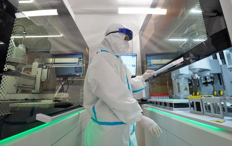 This photo taken on March 17, 2022 shows a staff member, wearing personal protective equipment (PPE), working at the Fire Eye laboratory, a temporary Covid-19 coronavirus testing facility, before it opens in Yantai in China's eastern Shandong province. (Photo by AFP) / China OUT