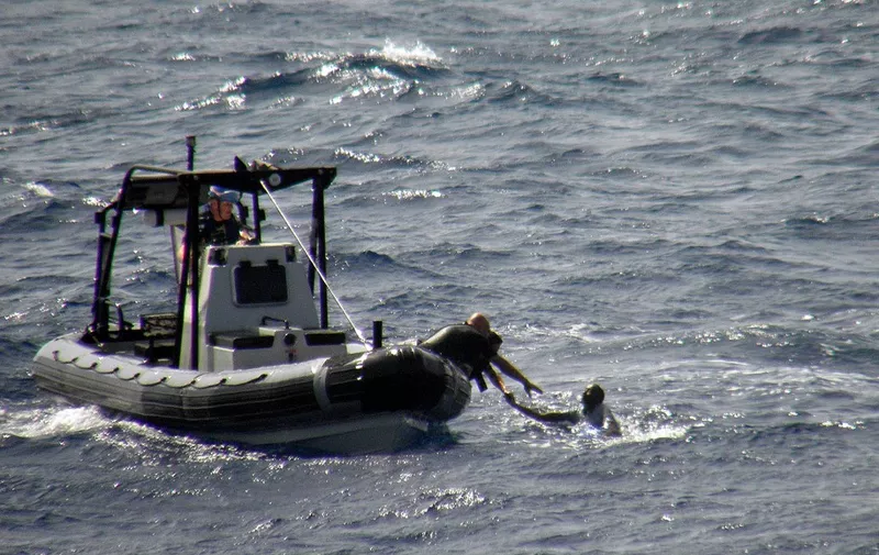This hand out picture released on September 15, 2009 by the Belgian navy shows a seaman rescuing a person from the Gulf of Aden on September 14, 2009. According to Belgian news sources, the Belgian frigate Louise-Marie came to the rescue of a sinking ship in waters between Somalia and Yemen and saved 38 of the 46 people onbaord. AFP PHOTO/BELGA/HAND OUT/BELGIAN DEFENCE   ---BELGIUM OUT--- (Photo by HO / BELGA / AFP)