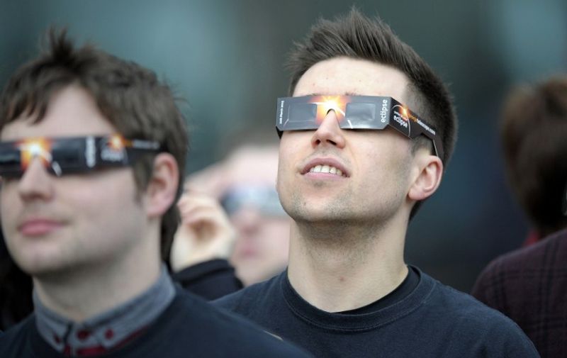 A young man wears protective glasses to view the partial solar eclipse at the Glasgow Science Centre in Glasgow, Scotland on March 20, 2015. AFP PHOTO / ANDY BUCHANAN / AFP PHOTO / Andy Buchanan