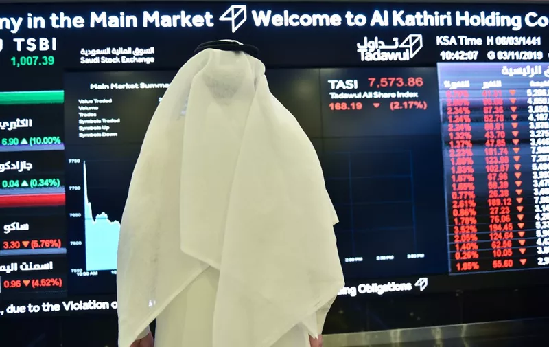 A Saudi man monitors an exchange board at the Stock Exchange Market (Tadawul) bourse in Riyadh on November 3, 2019. - Saudi Aramco confirmed it planned to list on the Riyadh stock exchange, describing it as a "significant milestone" in the history of the energy giant. (Photo by Fayez Nureldine / AFP)