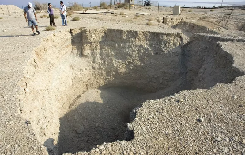 A sinkhole caused by the opening of cavernous is seen near the Ein Gedi Spa on the shores of the Dead Sea on September 10, 2008. As Israeli holidaymakers watch the Dead Sea retreating, leaving massive sinkholes in its wake, Palestinian farmers farther up the valley pry crops from increasingly parched soil. The Jordan Valley is in the grip of a severe water crisis, exacerbated by the region's various conflicts, that threatens the livelihoods of its Israeli and Arab residents. And it is transforming the landscape before their eyes. AFP PHOTO/JONATHAN NACKSTRAND