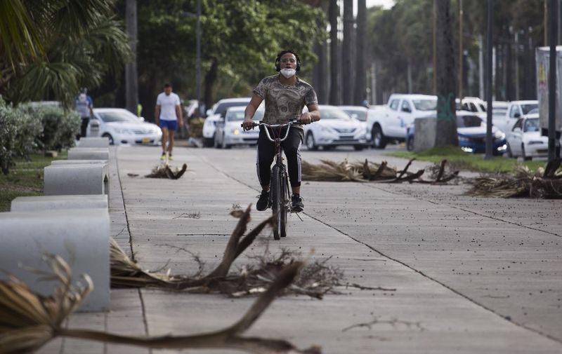A cyclist rides along the seafront in Santo Domingo on July 29, 2020. - Dominican Republic's Emergency Operation Center (COE) increased the alert level from yellow to red for four provinces and Santo Domingo, ahead of the possible passage through the country of tropical storm Isaias. (Photo by Erika SANTELICES / AFP)