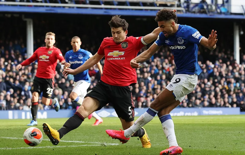 LIVERPOOL, ENGLAND - MARCH 01: Dominic Calvert-Lewin of Everton shoots as he is put under pressure by Harry Maguire of Manchester United during the Premier League match between Everton FC and Manchester United at Goodison Park on March 01, 2020 in Liverpool, United Kingdom. (Photo by Clive Brunskill/Getty Images)