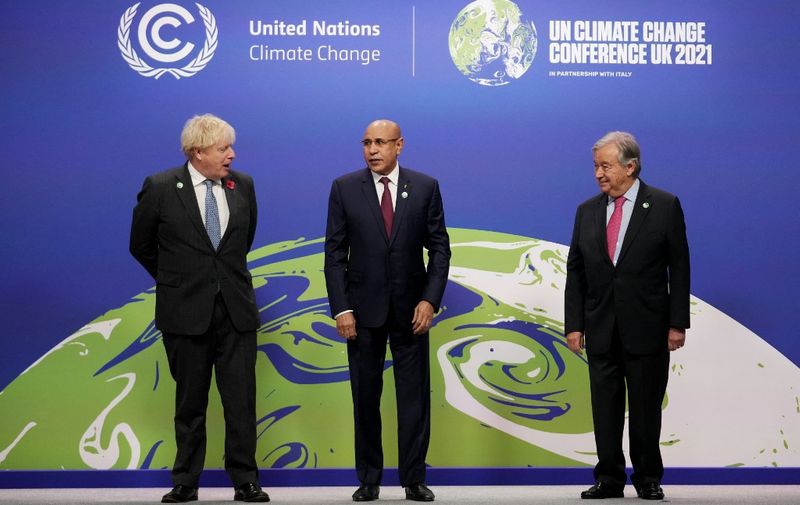 Britain's Prime Minister Boris Johnson (L) and United Nations (UN) Secretary General Antonio Guterres (R) greets Mauritania's President Mohamed Ould Ghazouani (C) as he arrives to attend day two of the COP26 UN Climate Change Conference in Glasgow, Scotland on November 1, 2021. - COP26, running from October 31 to November 12 in Glasgow will be the biggest climate conference since the 2015 Paris summit and is seen as crucial in setting worldwide emission targets to slow global warming, as well as firming up other key commitments. (Photo by Christopher Furlong / POOL / AFP)