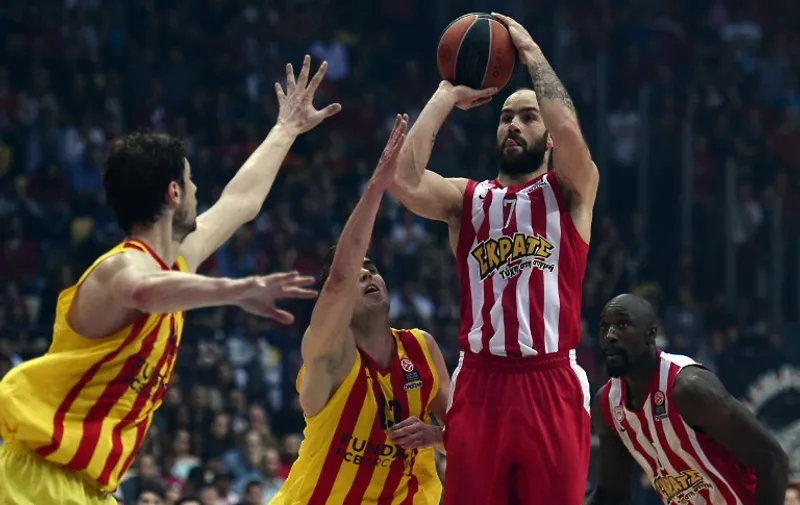 Olympiacos Piraeus' Vassilis Spanoulis (C-R)     scores  past  Barcelona's Czech guard Tomas Satoransky  (C) during their play off  Euroleague basketball match at the Peace and Friendship stadium in Piraeus district of Athens on April 23, 2015. 