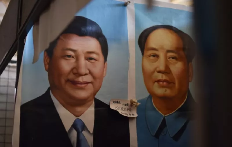 (FILES) This file picture taken on September 19, 2017 shows painted portraits of Chinese President Xi Jinping (L) and late communist leader Mao Zedong at a market in Beijing. 
China's Communist Party added President Xi Jinping's name to its constitution on October 24, 2017, confirming his status as the nation's most powerful leader in decades. / AFP PHOTO / GREG BAKER / TO GO WITH:  CHINA-CONGRESS-POLITICS-MAO BY PATRICK BAERT XGTY