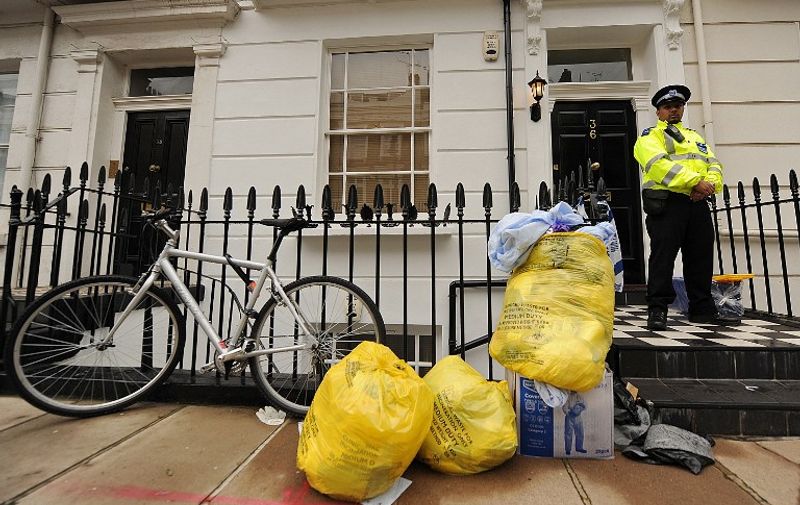 A police officer stands guard outside of the entrance to a flat where the body of Gareth Williams was discovered earlier this week, in central London on August 26, 2010.  Further tests were being carried out Thursday on the body of a British spy whose remains were found stuffed into a holdall in his flat in London.   Police discovered the remains of Williams, 30, on Monday in the top-floor flat of an upmarket building within walking distance of the headquarters of the foreign intelligence agency MI6 on the River Thames.    AFP PHOTO / BEN STANSALL