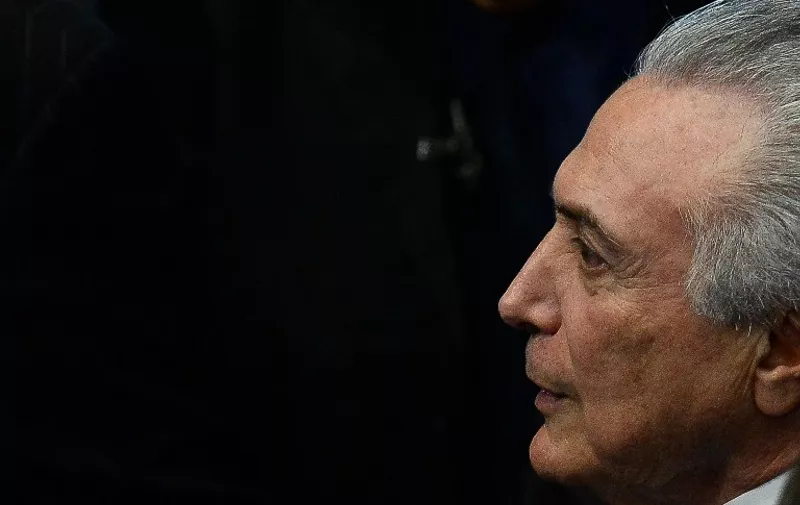 President Michel Temer as he takes office before the plenary of the Brazilian Senate in Brasilia, on August 31, 2016. 
Brazil's Dilma Rousseff was stripped of the country's presidency in an impeachment vote Wednesday and replaced by her bitter rival Michel Temer, shifting Latin America's biggest economy sharply to the right. / AFP PHOTO / ANDRESSA ANHOLETE