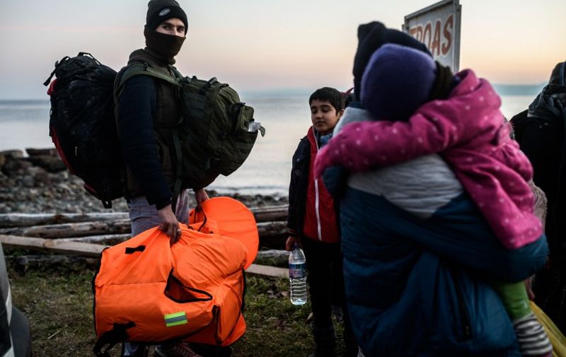 Syrian and Afghan migrants and refugees wait after being caught by Turkish gendarme on January 27, 2016 at Canakkale's Kucukkuyu district.
The European Commission said Greece could face border controls with the rest of the EU's passport-free Schengen zone if it fails to secure its exterior borders, with thousands of migrants still landing on Greek beaches from Turkey day after day.  / AFP / OZAN KOSE