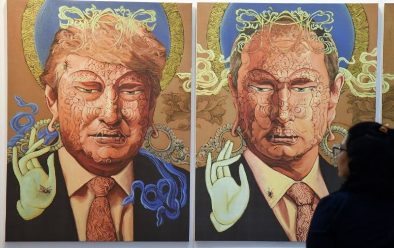 A visitor looks at a painting representing US President Donald Trump (L) and Russian President Vladimir Putin made by Nepalese artist Sunil Sidgel at the India Art Fair in New Delhi on January 2, 2017. / AFP PHOTO / Dominique FAGET / RESTRICTED TO EDITORIAL USE - MANDATORY MENTION OF THE ARTIST UPON PUBLICATION - TO ILLUSTRATE THE EVENT AS SPECIFIED IN THE CAPTION
