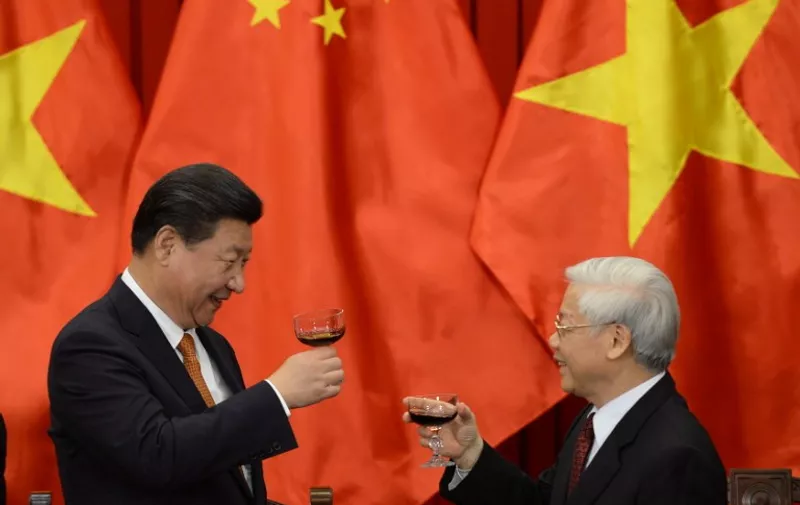 Chinese President Xi Jinping (L) and Vietnam Communist Party Secretary General Nguyen Phu Trong raise a toast after witnessing a signing ceremony of a dozen of  bilateral agreements following their official talks at the VCP's Headquarters in Hanoi on November 5, 2015. Chinese President Xi Jinping Thursday said he hoped for a "higher level" partnership with Vietnam on a visit that has angered Vietnamese nationalists at a time of bubbling conflict over the South China Sea. AFP PHOTO / POOL / HOANG DINH NAM / AFP PHOTO / POOL / HOANG DINH NAM