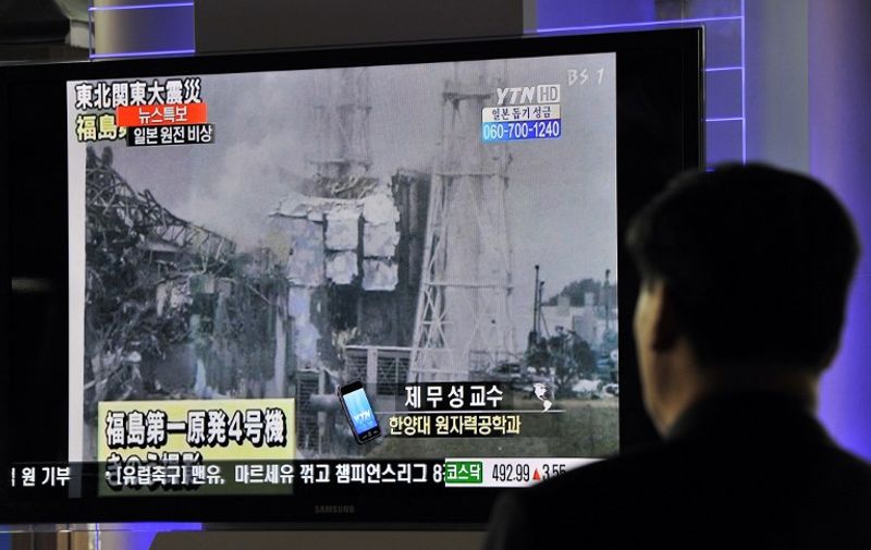 South Korean passengers walk past a TV reporting an explosion and feared meltdown of Japan's Fukushima-Daiichi Nuclear Power Plant after a massive quake, at a railway station in Seoul on March 16, 2011. South Korea said it plans to send an emergency shipment of cooling material to Japan to help control its quake-damaged nuclear reactors.  AFP PHOTO/JUNG YEON-JE / AFP PHOTO / JUNG YEON-JE