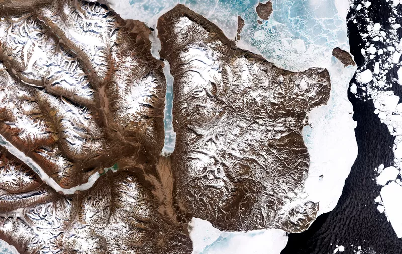 Ranging in color from snow white to turquoise, sea ice lined the shoreline in eastern Greenland in mid-June 2000. NASA's Landsat 7 satellite acquired this image on June 16, 2000, shortly before the summer solstice when the Arctic enjoyed near round-the-clock sunshine.  Although snow and ice abound in this image, both are in retreat for the summer. Snowcaps form dendritic patterns on the brown landscape, leaving south-facing slopes especially bare. Around the Hold with Hope promontory, fast ice clings to the shoreline. Common over shallow ocean waters along shorelines, fast ice holds fast to the shore and/or sea bottom, not moving with winds or currents. Off the coast, pieces of bright white sea ice float on the sea surface, able to move with forces that don's affect the fast ice.  Much of the fast ice in this image is blue, especially in the fjord north of Hold with Hope. Summer melt often lends ice a blue color due to water saturation. In addition, this ice could be what is known as blue ice, or ice composed of large crystals. Light that is visible to human eyes is composed of three basic components: red, green, and blue. Pure ice absorbs a miniscule amount of red light, reflecting slightly more green and blue light. This red-light absorption is lost in the noise of tiny snow crystals, the same way a piece of colored hard candy might appear white if it were pulverized. Large ice crystals make the red-light absorption visible to human eyes, just as sufficiently large pieces of glass would show a very subtle tint.  The relentless action of wind can transform snow crystals to large ice crystals. Away from the coast, snakes of ice make their way through inland fjords, and some of this ice is also blue.