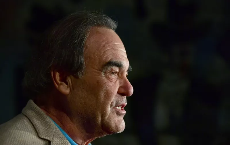 US director Oliver Stone speaks to reporters as he arrives for a reception for the Cinema for Peace Foundation on February 12, 2017 in Berlin. / AFP PHOTO / John MACDOUGALL