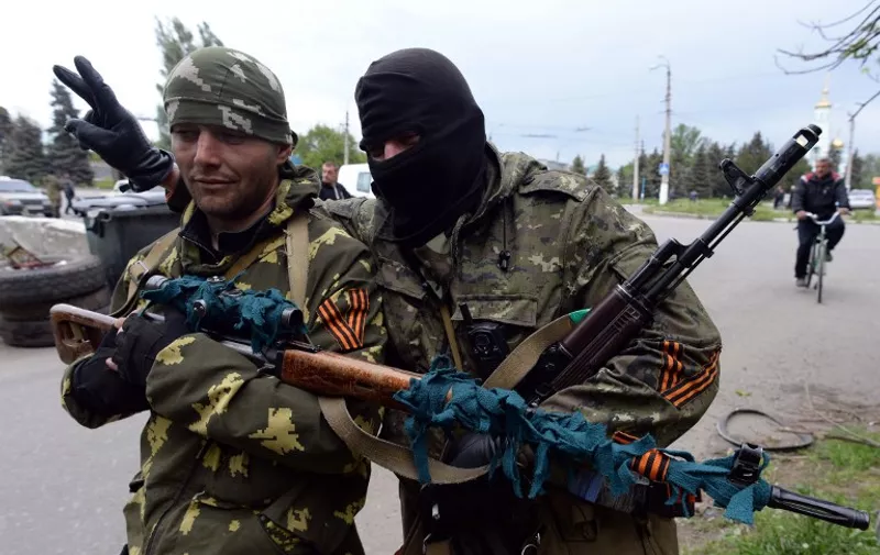 (FILES) This picture taken in the eastern Ukranian city of Slavyansk on May 8, 2014 shows armed pro-Russia militiants bearing so-called St George's. The ribbon, which is given out for free in Russia in a state-sponsored campaign, is a symbol of pride in Soviet victory in World War II it is also worn by pro-Russian separatists in eastern Ukraine. Russia prepares to celebrate the 70th anniversary of the Soviet victory over Nazi in the World War II, on May 9, 1945. AFP PHOTO / VASILY MAXIMOV