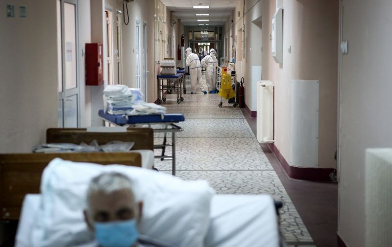 Medical workers escort a patient suffering from coronavirus disease (COVID-19) inside the Institute for Orthopaedic Surgery "Banjica", recently transformed to a COVID hospital, in Belgrade on July 14, 2020. A candidate for the European Union, this small Balkan country is experiencing a resurgence of the pandemic, which has sparked several evenings of violent demonstrations to denounce the government's management of the health crisis. With 300 new cases now detected every day, Serbia is approaching April levels, at the peak of the first wave.,Image: 542784820, License: Rights-managed, Restrictions: To go with AFP story Anguish in Serbia as COVID-19 returns with a vengeance" by Jovan MATIC and Nicolas GAUDICHET, Model Release: no