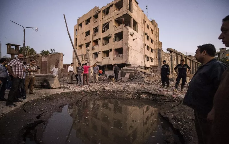 Egyptian policemen stand in front of a bomb-damaged national security building in northern Cairo's district of Shubra on August 20, 2015. A car bomb wounded six Egyptian policemen as it exploded in front of a police building, the interior ministry said, the latest in a wave of militant attacks that has rocked Egypt.    AFP PHOTO / KHALED DESOUKI