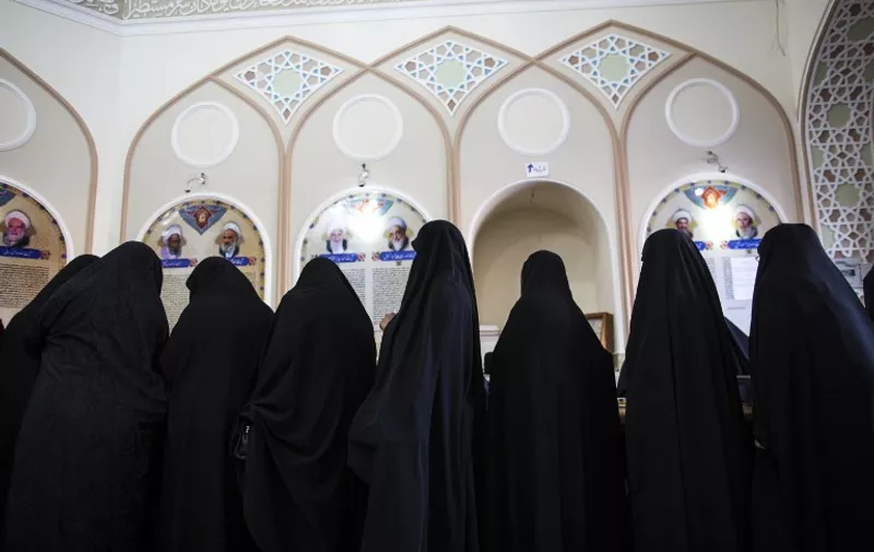 Iranian women line up to vote for both parliamentary elections and the Assembly of Experts at a polling station at the Massoumeh shrine in the holy city of Qom, 130 kms south of Tehran, on February 26, 2016. Iranians began voting across the country in elections billed by the moderate president as vital to curbing conservative dominance in parliament and speeding up domestic reforms after a nuclear deal with world powers. AFP PHOTO/BEHROUZ MEHRI / AFP PHOTO / BEHROUZ MEHRI
