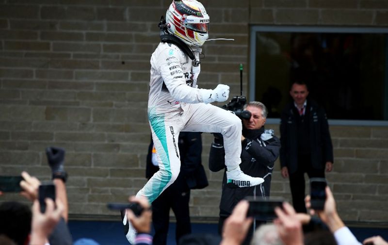 AUSTIN, TX - OCTOBER 25: Lewis Hamilton of Great Britain and Mercedes GP jumps in the air in Parc Ferme after winning the United States Formula One Grand Prix and the championship at Circuit of The Americas on October 25, 2015 in Austin, United States.   Mark Thompson/Getty Images/AFP