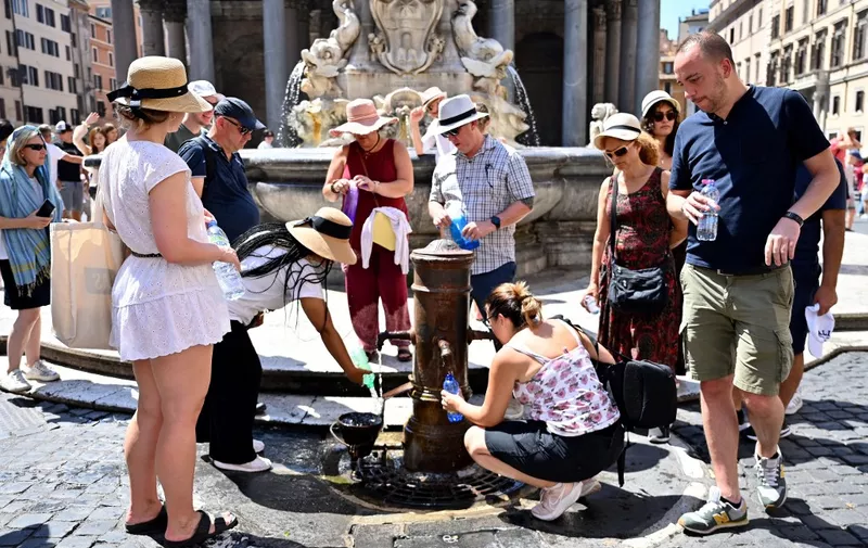 People queue to fill bottle with water at a public tap at Piazza della Rotonda in Rome on July 11, 2023. A substantial increase of temperatures is expected in Europe in the next days. (Photo by Alberto PIZZOLI / AFP)