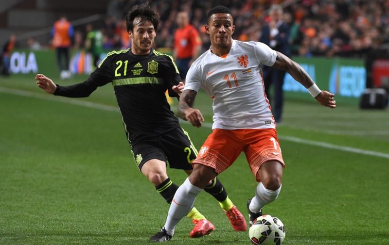 Netherland's Memphis Depay (R) vies with Spain's David Silva during the  friendly football match Netherlands vs Spain in Amsterdam, on March 31, 2015. AFP PHOTO/Emmanuel Dunand