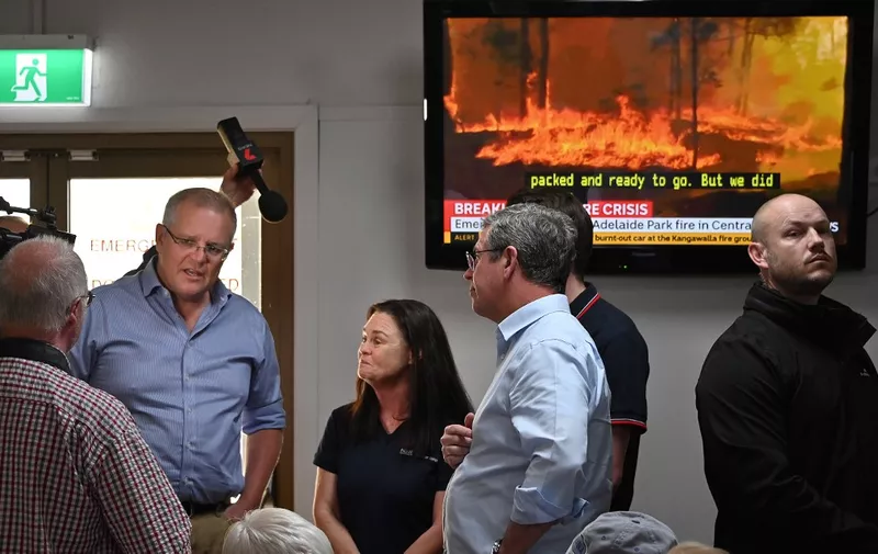 Australian Prime Minister Scott Morrison (L) speaks to residents and officials at an evacauation centre in Taree 350km north of Sydney on November 10, 2019 as firefighters try to contain dozens of out-of-control blazes that are raging in the state of New South Wales. - Three people are known to have have died and 150 homes have been destroyed as an unprecedented number of bushfires tore through eastern Australia. (Photo by PETER PARKS / AFP)