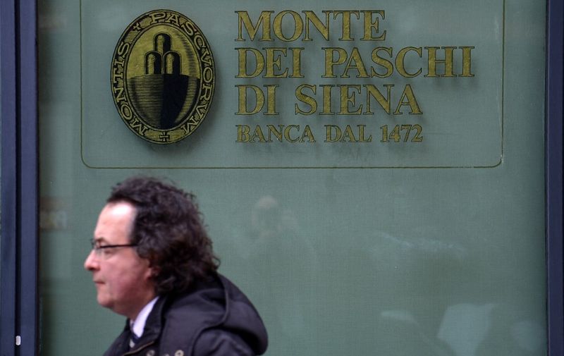 A man walks past a branch of the Monte dei Paschi di Siena bank in downtown Rome on February 09, 2017. - Banca Monte dei Paschi di Siena S.p.A. (BMPS) is the oldest surviving bank in the world and the third largest Italian commercial and retail bank by total assets. Founded in 1472 by the magistrates of the city state of Siena, as a "mount of piety", it has been operating ever since. In 1995 the bank, then known as Monte dei Paschi di Siena, was transformed from a statutory corporation to a limited company called Banca Monte dei Paschi di Siena (Banca MPS). Since the end of 2016, the bank is struggling to avoid a collapse. (Photo by FILIPPO MONTEFORTE / AFP)