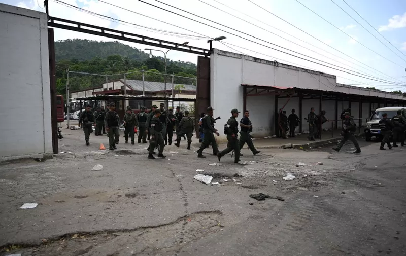 Members of the Bolivarian National Guard (GNB) walk outside the Tocoron prison after authorities seized control of the prison in Tocoron, Aragua State, Venezuela, on September 20, 2023. Venezuela said Wednesday it had seized control of a prison from the hands of a powerful gang with international reach, in a major operation involving 11,000 members of its security forces. (Photo by YURI CORTEZ / AFP)