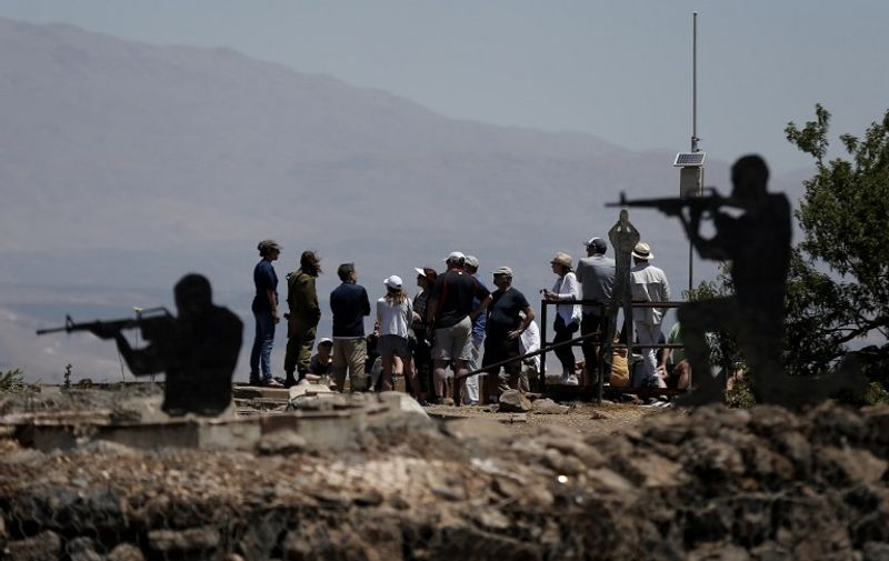Sculptures of Israeli soldiers standing guard are seen as tourists visit an Israeli army post on Mount Bental in the Israeli-annexed Golan Heights on June 23, 2015. Two wounded Syrians were attacked, leaving one dead and the second in a serious condition after around 200 Israeli Druze from the village of Majdal Shams on the Golan Heights attacked an Israeli military ambulance overnight taking the Syrians to hospital for treatment. AFP PHOTO / THOMAS COEX