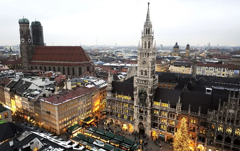 Overall view of Munich's Marienplatz, featuring the town hall (C) and the Frauenkirche (L- Church of Our Lady) taken on December 14, 2009. During the December Christmas market, visitors can buy traditional bakery, hot punch, gingerbread and craftwork at around a hundred market stands. AFP PHOTO / JOHN MACDOUGALL (Photo by John MACDOUGALL / AFP)