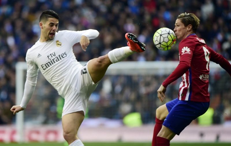 Real Madrid's midfielder Isco (L) vies with Atletico Madrid's forward Fernando Torres during the Spanish league football match Real Madrid CF vs Club Atletico de Madrid at the Santiago Bernabeu stadium in Madrid on February 27, 2016. / AFP / PIERRE-PHILIPPE MARCOU