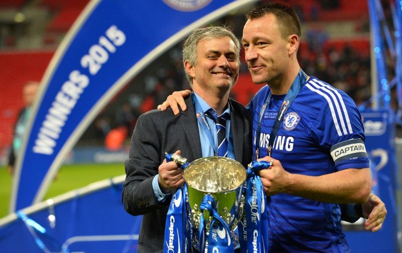 Chelsea's Portuguese manager Jose Mourinho (L) and Chelsea's captain, English defender John Terry (R) celebrate with the trophy during the presentation after Chelsea won the League Cup final football match against Tottenham Hotspur at Wembley Stadium in London on March 1, 2015. Chelsea won 2-0. AFP PHOTO / GLYN KIRK

RESTRICTED TO EDITORIAL USE. No use with unauthorized audio, video, data, fixture lists, club/league logos or live services. Online in-match use limited to 45 images, no video emulation. No use in betting, games or single club/league/player publications.