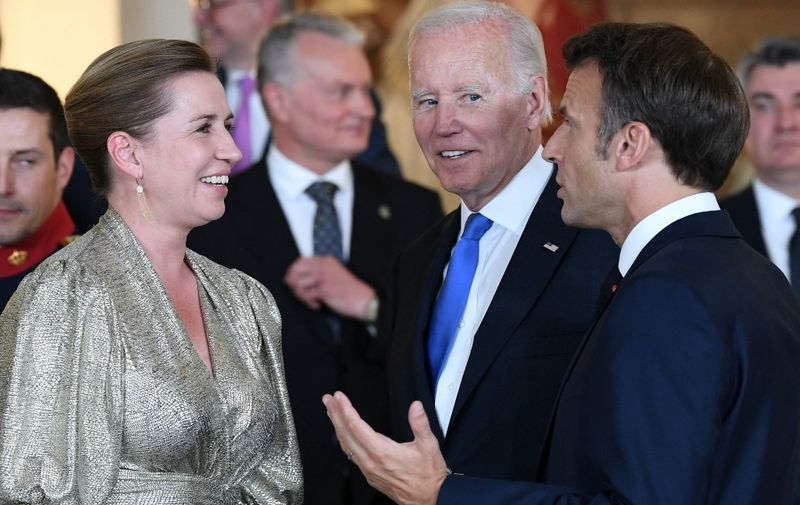 Denmark's Prime Minister Mette Frederiksen, US President Joe Biden and French President Emmanuel Macron talk after a family picture before a dinner hosted by the Spanish royal couple with those invited to the official NATO Summit program at the Royal Palace in Madrid, on June 28, 2022. (Photo by BERTRAND GUAY / POOL / AFP)