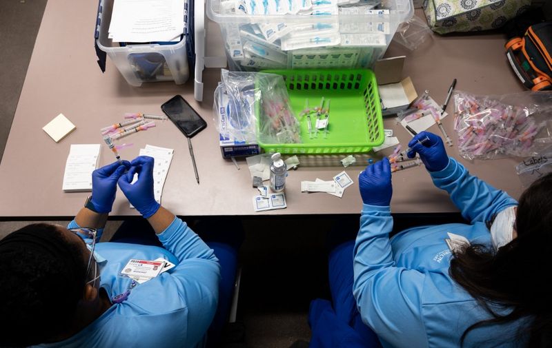 LOUISVILLE, KY - MARCH 15: Nurses Jasmine Cowherd (L) and Tammi Richardson (R) fill syringes with doses of the Johnson &amp; Johnson COVID-19 vaccine at Wayside Christian Mission on March 15, 2021 in Louisville, Kentucky. Norton Healthcare, in coordination with Metro Louisville and Louisville Public Health and Wellness, held a COVID vaccination event at Wayside Christian Mission for the many people without homes served at that location.   Jon Cherry/Getty Images/AFP (Photo by Jon Cherry / GETTY IMAGES NORTH AMERICA / Getty Images via AFP)