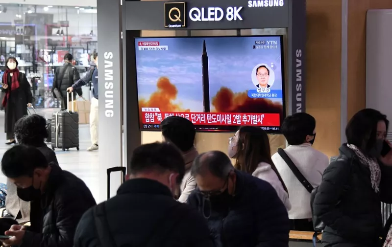 People watch a television screen showing a news broadcast with file footage of a North Korean missile test, at a railway station in Seoul on November 3, 2022. - North Korea fired one long-range and two short-range ballistic missiles on November 3, Seoul's military said, with one prompting warnings for residents of a South Korean island and people in parts of northern Japan to seek shelter. (Photo by Jung Yeon-je / AFP)