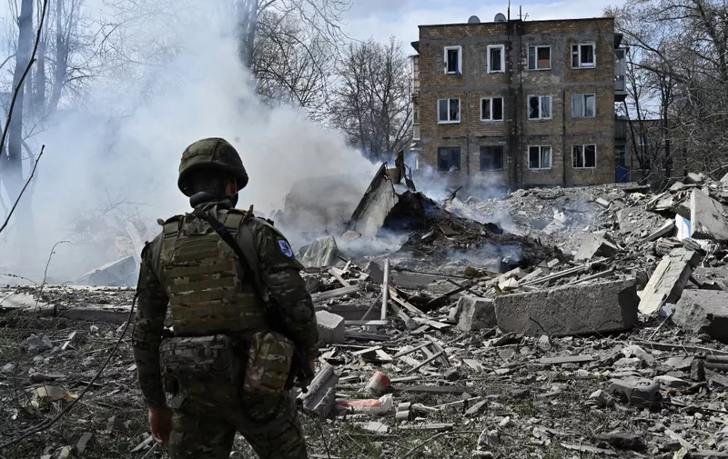 A member of the Ukrainian White Angels Special Police Team looks at debris of a residential building, destroyed following an air strike in the frontline town of Avdiivka, Donetsk region on April 10, 2023, amid the Russian invasion of Ukraine. (Photo by Genya SAVILOV / AFP)