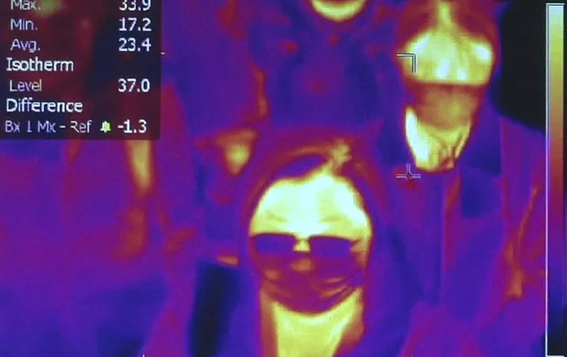 This photo grabbed from a video taken and handout on January 23, 2020 by Rome's Fiumicino Airport Authority (ADR) shows passengers scanned by thermal imaging for body temperature as they go through  health measures and procedures against deadly SARS-like virus outbreak risks, after they landed at Rome's Fiumicino airport on a southern airlines flight from Wuhan, China. - China banned trains and planes from leaving a major city at the centre of a virus outbreak on January 23, seeking to seal off its 11 million people to contain the contagious disease that has claimed 17 lives, infected hundreds and spread to other countries. (Photo by Handout / AEROPORTO DI ROMA / AFP) / RESTRICTED TO EDITORIAL USE - MANDATORY CREDIT "AFP PHOTO / ROME AIRPORT AUTHORITY / AEROPORTO DI ROMA" - NO MARKETING - NO ADVERTISING CAMPAIGNS - DISTRIBUTED AS A SERVICE TO CLIENTS