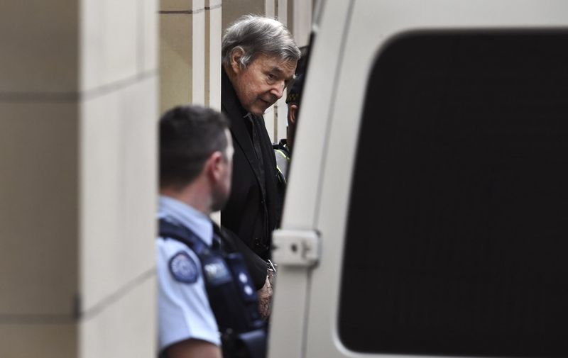 Australian Cardinal George Pell (C) is escorted in handcuffs from the Supreme Court of Victoria in Melbourne on August 21, 2019. - Disgraced Catholic Cardinal George Pell was sent back to jail after an Australian court rejected his landmark appeal against convictions for child sex abuse. (Photo by William WEST / AFP)