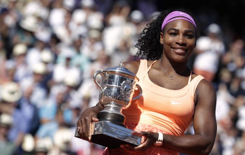 US Serena Williams celebrates with the trophy following her victory over Czech Republic's Lucie Safarova at the end of the women's final match of the Roland Garros 2015 French Tennis Open in Paris on June 6, 2015.  AFP PHOTO / KENZO TRIBOUILLARD