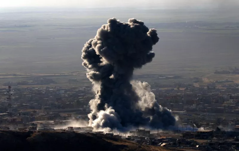 Heavy smoke billows during an operation by Iraqi Kurdish forces backed by US-led strikes in the northern Iraqi town of Sinjar on November 12, 2015, to retake the town from the Islamic State group and cut a key supply line to Syria. The autonomous Kurdish region's security council said up to 7,500 Kurdish fighters would take part in the operation, which aims to retake Sinjar "and establish a significant buffer zone to protect the (town) and its inhabitants from incoming artillery." AFP PHOTO / SAFIN HAMED