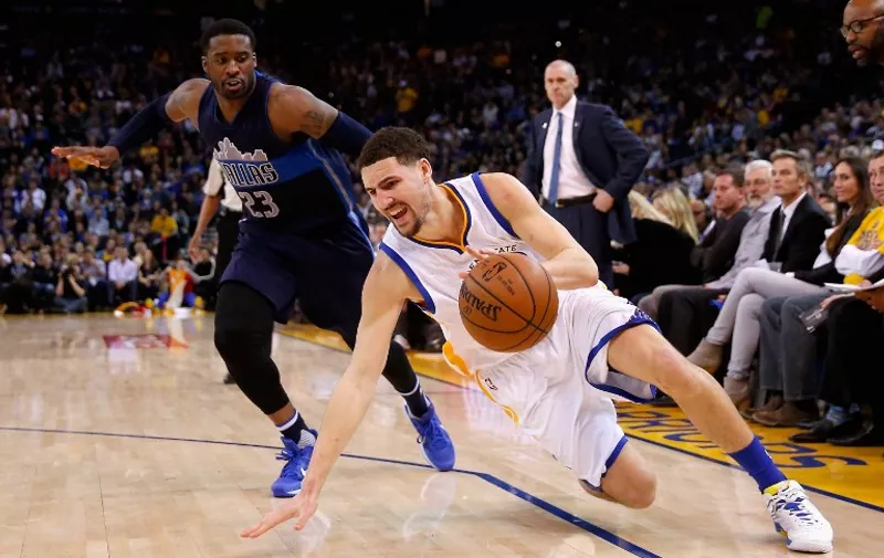 OAKLAND, CA - JANUARY 27: Klay Thompson #11 of the Golden State Warriors slips while being guarded by Wesley Matthews #23 of the Dallas Mavericks at ORACLE Arena on January 27, 2016 in Oakland, California. NOTE TO USER: User expressly acknowledges and agrees that, by downloading and or using this photograph, User is consenting to the terms and conditions of the Getty Images License Agreement.   Ezra Shaw/Getty Images/AFP