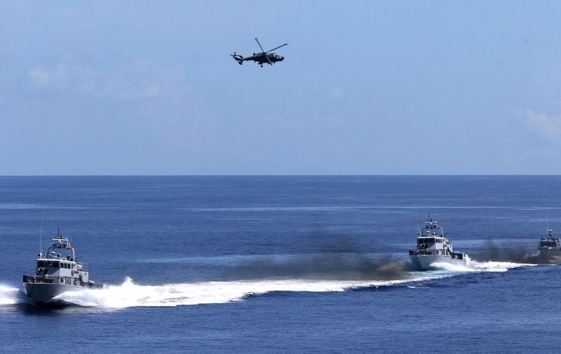 Philippine navy AW159 anti-submarine helicopter (top) hovers above patrol boats during a navy's capability demonstration, witnessed by Philippine President Ferdinand Marcos Jr. (not pictured) aboard the Philippine navy ship BRP Davao del Sur, a Tarlac-class landing platform dock, off Zambales, facing the South China Sea on May 19, 2023. (Photo by ALI VICOY / POOL / AFP)