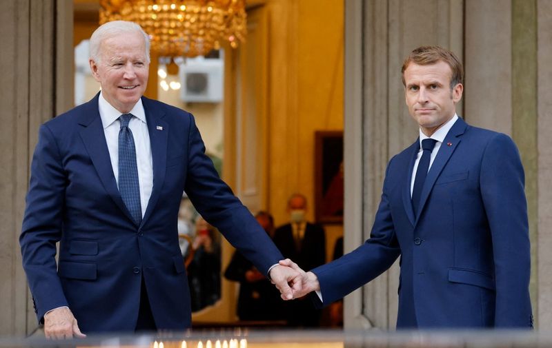 French President Emmanuel Macron (R) welcomes US President Joe Biden (L) before their meeting at the French Embassy to the Vatican in Rome on October 29, 2021. (Photo by Ludovic MARIN / AFP)