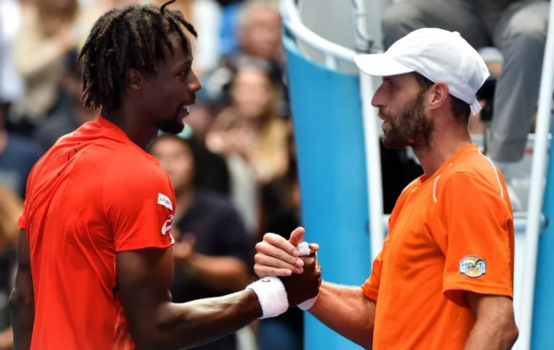 France's Gael Monfils (L) is congratulated by France's Stephane Robert during their men's game on day six of the 2016 Australian Open tennis tournament in Melbourne on January 23, 2016. AFP PHOTO / PAUL CROCK  -- IMAGE RESTRICTED TO EDITORIAL USE - STRICTLY NO COMMERCIAL USE / AFP / PAUL CROCK