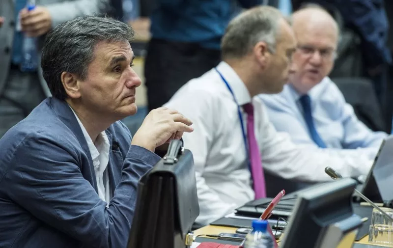 Greek Finance Minister Euclid Tsakalotos (L) attends a meeting of the Eurogroup finance ministers in Brussels on July 12, 2015. The EU cancelled a full 28-nation summit today to decide Greece's fate in the single European currency, although a meeting of leaders from the 19 countries in the eurozone will go ahead as planned.  AFP PHOTO / JOHN MACDOUGALL