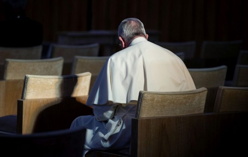 This handout picture taken and released by the Vatican press Office - Osservatore Romano on March 11, 2016 shows Pope Francis  prayING prior to leave his spiritual retreat with the Roman curia in Ariccia a small village near Rome, on March 11, 2016. / AFP / OSSERVATORE ROMANO / OSSERVATORE ROMANO